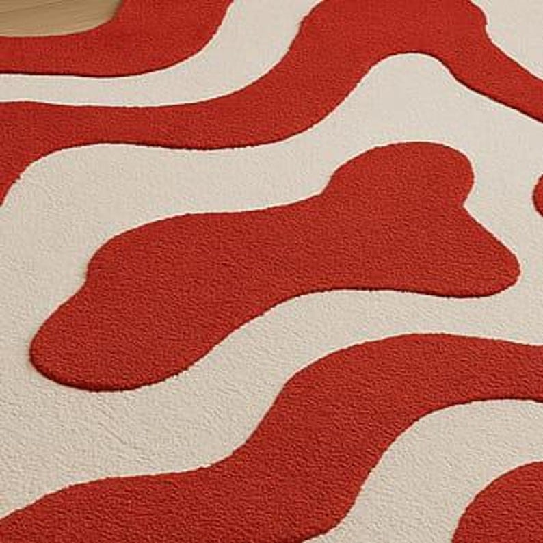 Hand-tufted bold red and white abstract rug with irregular amoeba shape and sculptural wavy layers. Modern retro design perfect for living rooms, bedrooms, or artistic spaces. Handmade custom wool rug adds visual interest and a fun pop of color to minimalist or boho interiors. Soft, cozy, and durable area rug ideal for under coffee tables or sofas. Unique sculpted carpet designed to elevate home decor with a bold and stylish statement.