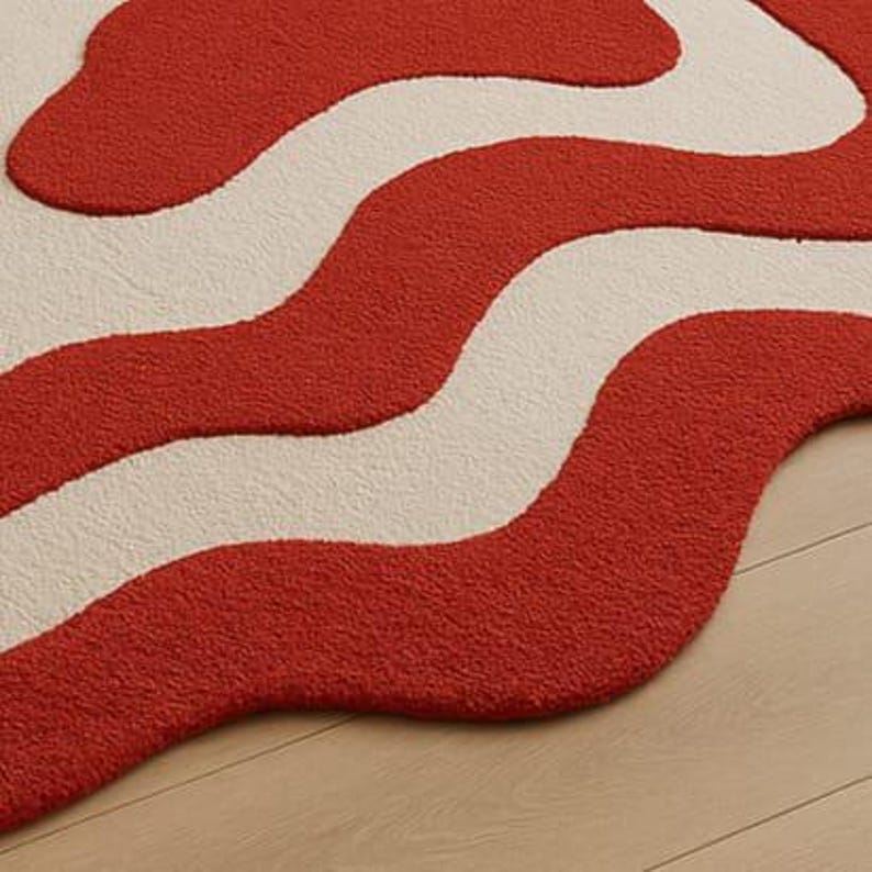 Hand-tufted bold red and white abstract rug with irregular amoeba shape and sculptural wavy layers. Modern retro design perfect for living rooms, bedrooms, or artistic spaces. Handmade custom wool rug adds visual interest and a fun pop of color to minimalist or boho interiors. Soft, cozy, and durable area rug ideal for under coffee tables or sofas. Unique sculpted carpet designed to elevate home decor with a bold and stylish statement.