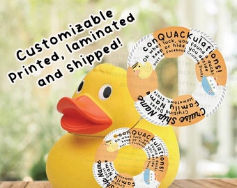 May include: A yellow rubber duck with two orange rings around it. The rings have text that says "conQUACKulations! Oh what luck, you found a duck! Keep or hide, you decide! Post on Facebook Cruising Ducks!" and "Cruise Ship Name, Family Name, Cruising Dates, Hometown, State".