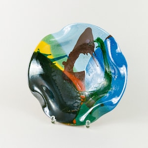 Könnte beinhalten: Eine wellenförmige, blaue, grüne, gelbe und braune Glasschale mit einem einzigartigen abstrakten Design.