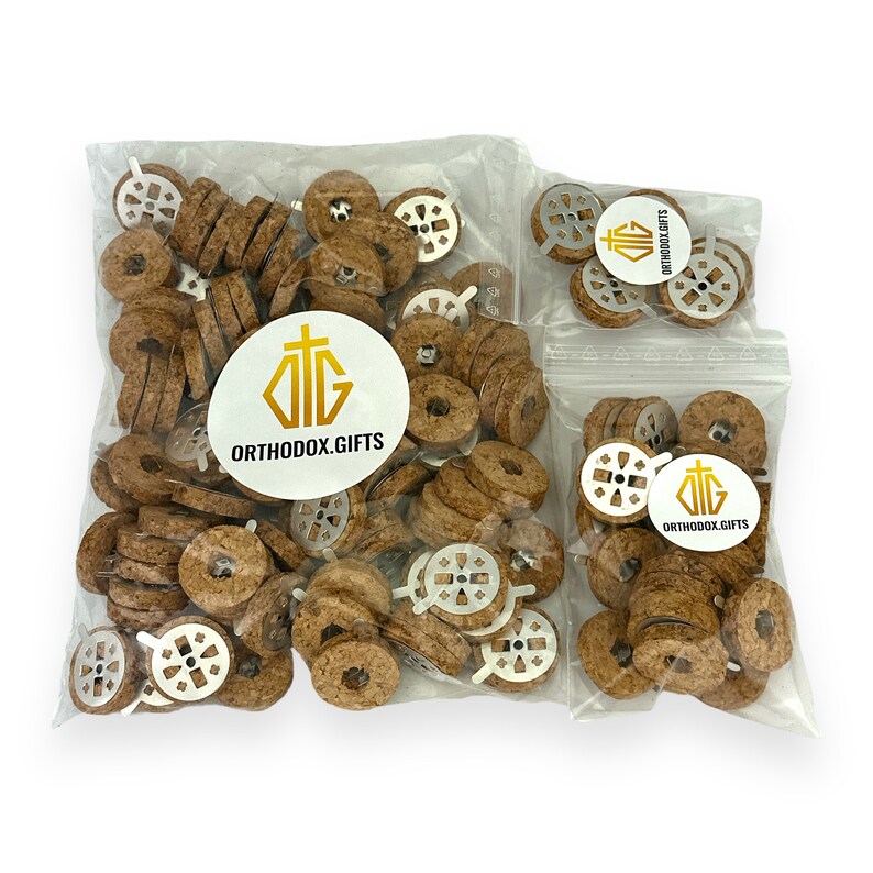 May include: Two bags of cork candle holders with a metal cross design. The bags are labeled with the logo "Orthodox Gifts".