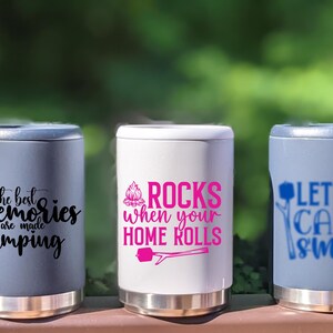 Puede incluir: Tres enfriadores de latas de acero inoxidable con diferentes dise&ntilde;os de tem&aacute;tica de campamento. El primer enfriador es gris con el texto "the best memories are made camping". El segundo enfriador es blanco con el texto "ROCKS when your HOME ROLLS" y un gr&aacute;fico de fogata rosa. El tercer enfriador es gris con el texto "LET'S CAMP SMORE" y un gr&aacute;fico de fogata azul.
