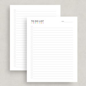May include: Two white To Do List notepads. The top notepad has the words "TO DO LIST" in black text with colorful dots above the lines. The second notepad is partially visible behind the first. Both notepads have lines and check boxes.