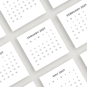 Könnte beinhalten: Mehrere weiße quadratische Kalender für das Jahr 2027 werden gezeigt. Die Monate Januar, Februar und Mai sind sichtbar. Die Kalender haben ein minimalistisches Design mit schwarzem Text. Maße sind nicht zutreffend.
