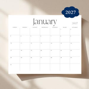 May include: A minimalist white calendar page for January 2027. The word "January" is elegantly displayed at the top, with the year 2027 in a navy blue cloud shape. The calendar grid is simple and clean.