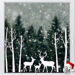 Può includere: Silhouette bianca di una famiglia di cervi con un cervo, una cerva e un cerbiatto in piedi in una foresta innevata con betulle bianche. Lo sfondo è un'immagine sfocata di una foresta innevata.