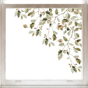 Könnte beinhalten: Ein Fensteraufkleber mit einer Aquarellillustration von Eichenzweigen mit grünen Blättern und braunen Eicheln. Das Design ist in einem Eckmuster angeordnet und zeigt detaillierte botanische Elemente in verschiedenen Grün- und Brauntönen auf transparentem Grund.