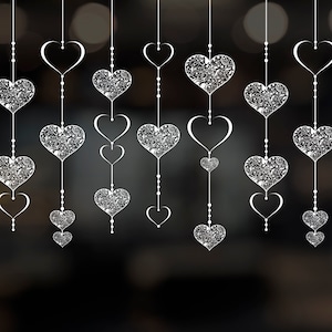 May include: A string of white heart-shaped ornaments with intricate designs hanging from a ceiling. The hearts are connected by small white beads.