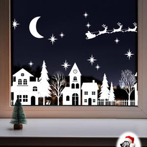 May include: A white vinyl window decal featuring a Christmas village scene with houses, pine trees, and bare trees. The design includes a crescent moon, stars, and a silhouette of Santa Claus in a sleigh pulled by reindeer. Dilly Duck Design logo.