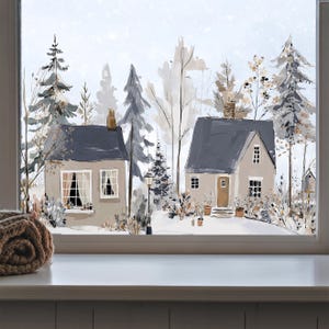 Könnte beinhalten: Ein Fensteraufkleber mit einer Winterszene, die zwei Häuser, schneebedeckten Boden und immergrüne Bäume in Grau-, Beige- und Weißtönen zeigt. Ein zusammengerolltes braunes Stricktextil liegt auf dem weißen Fensterbrett im Vordergrund.