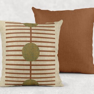 two throw pillows, one with a striped pattern and the other with a solid color.