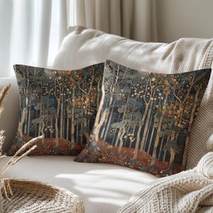 two decorative throw pillows with a forest scene design, placed on a couch in a cozy living room setting.