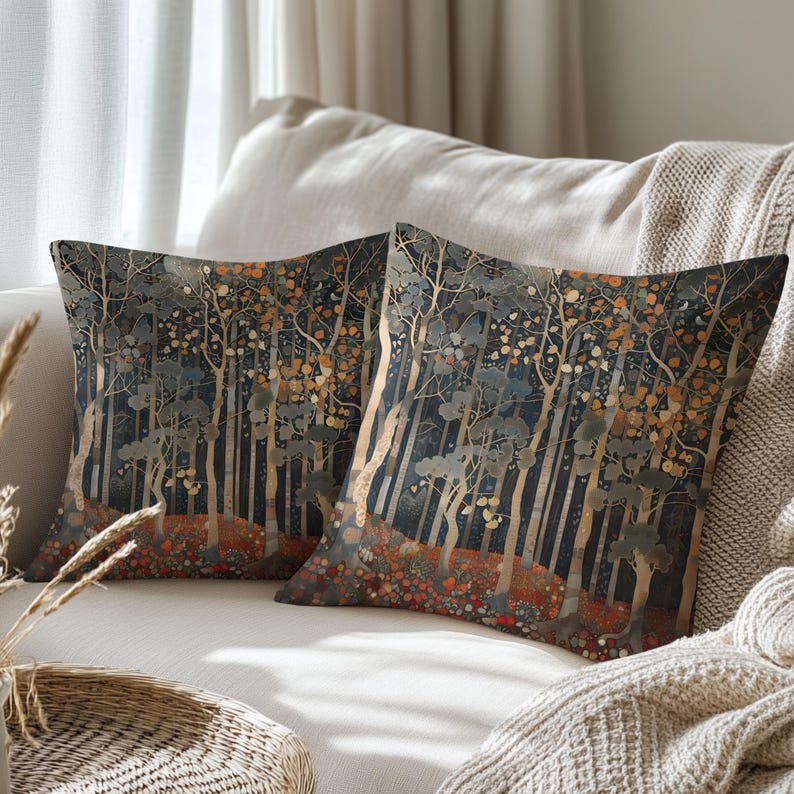 two decorative throw pillows with a forest scene design, placed on a couch in a cozy living room setting.