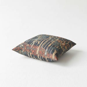 A single decorative pillow with a colorful, abstract pattern of stripes and shapes in shades of blue, orange, and green.