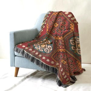A vibrant, patterned throw blanket is draped over the armrest of a light blue armchair, creating a cozy and inviting atmosphere.