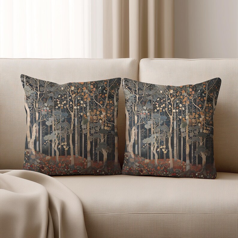two decorative throw pillows with a forest scene design, placed on a beige couch.