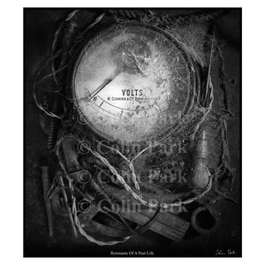 May include: Monochrome image of a vintage voltmeter, displaying "VOLTS" and "W. Canning & Co Birmingham." The meter is encased in cobwebs, with old tools and wires around it, suggesting a bygone era. The photograph is labelled "Remnants Of A Past Life."
