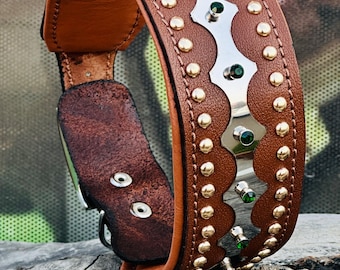May include: A brown leather dog collar with gold studs and a silver trim with green gemstones.