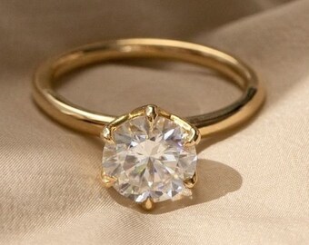 May include: A gold ring with a large, clear, round diamond.