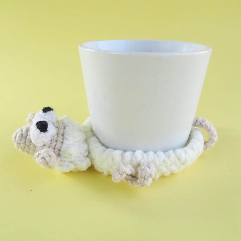 May include: A white ceramic mug with a black handle and the text "But First, Coffee" in a black, handwritten-style font. The mug is on a white surface.