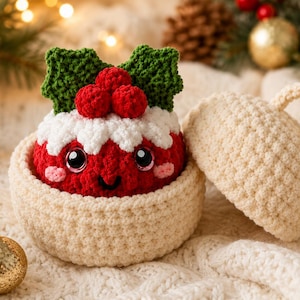 Peut inclure: Un personnage de pudding rouge au crochet avec un dessus en gla&ccedil;age blanc, des feuilles de houx vertes et des baies rouges, nich&eacute; dans un bol en crochet cr&egrave;me avec un couvercle assorti. Le pudding a des yeux noirs et un sourire rose.