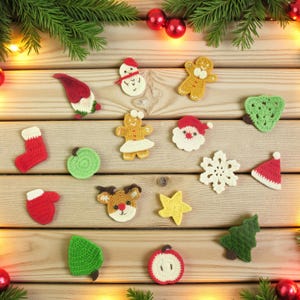 Könnte beinhalten: Eine Sammlung handgefertigter gehäkelter Weihnachtsschmuckstücke, darunter ein Schneemann, ein Lebkuchenmann, der Weihnachtsmann und ein Rentier, angeordnet auf einer Holzoberfläche mit festlichem Grün und Lichtern.