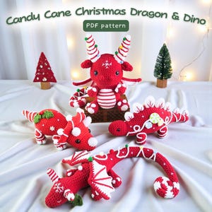 Puede incluir: Una colección de dragones y dinosaurios navideños de ganchillo rojos y blancos. Las figuras de dragones tienen cuernos y alas de bastón de caramelo, mientras que los dinosaurios presentan rayas y elementos decorativos de bastón de caramelo. El texto "Candy Cane Christmas Dragon & Dino" está en la parte superior.