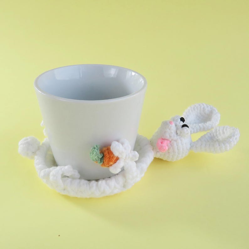 May include: A white ceramic mug with a black handle and the text "But First, Coffee" in a bold, black font. The mug is set against a blurred background, suggesting a cozy setting. The mug appears to be approximately 4 inches tall.