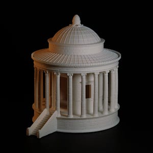 May include: A detailed, off-white miniature of a classical rotunda with a domed roof, columns, and a small staircase. The model is set against a black background, highlighting its architectural details.