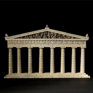 May include: A cream-coloured architectural model of a Greek temple featuring eight fluted columns supporting a detailed entablature and a triangular pediment filled with intricate relief sculptures of figures in various poses.
