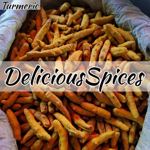 Op de afbeelding: Een close-up afbeelding van een grote stapel kurkumawortel, een heldergele specerij. De kurkuma bevindt zich in een jutezak en de tekst "Delicious Spices" is zichtbaar in de afbeelding.