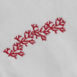 Könnte beinhalten: Rote Stickerei eines stilisierten Zweigs mit mehreren Verzweigungen auf einem weißen Stoffhintergrund.