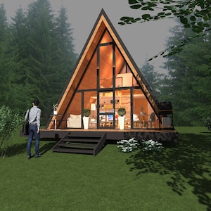 Könnte beinhalten: Ein A-Frame-Hütte mit dunklem Holzrahmen und großen Glasfenstern, eingebettet in einen Wald. Die Hütte hat eine kleine Terrasse und Stufen zum Eingang. Eine Person steht auf dem Rasen und blickt zur Hütte. Der Innenraum ist sichtbar, mit Möbeln und Beleuchtung.