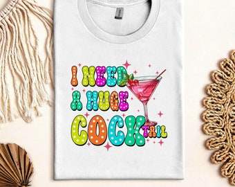 May include: White t-shirt with a colorful graphic that says "I need a huge cocktail" with a martini glass illustration.