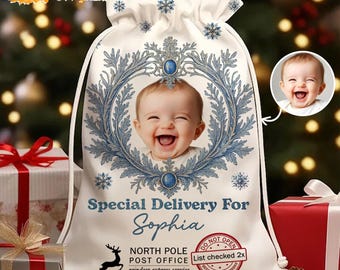 May include: A white drawstring Christmas gift bag with a baby's photo inside a blue and silver wreath. The bag reads "Special Delivery For Sophia" and includes a North Pole Post Office stamp and reindeer graphic.