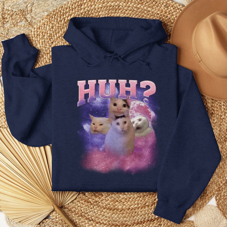 K&ouml;nnte beinhalten: Marineblauer Hoodie mit einem wei&szlig;en Katzen-Meme-Bild und dem Text "HUH?" auf der Vorderseite.