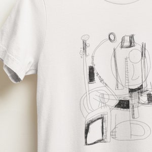 May include: A white t-shirt with a black and white abstract drawing of geometric shapes and lines.