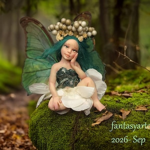 May include: A doll with teal hair, a dark green bodice, and white petal-like skirt, featuring large translucent green wings and a crown of small metallic spheres. The text "fantasyartooak 2026- Sep" is visible in the lower right corner.