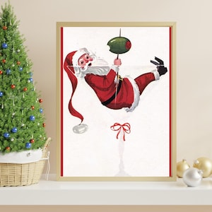 Op de afbeelding: Een vintage kerst-illustratie van Sinterklaas die ondersteboven hangt in een martini-glas met een olijf. De illustratie is in een gouden lijst.