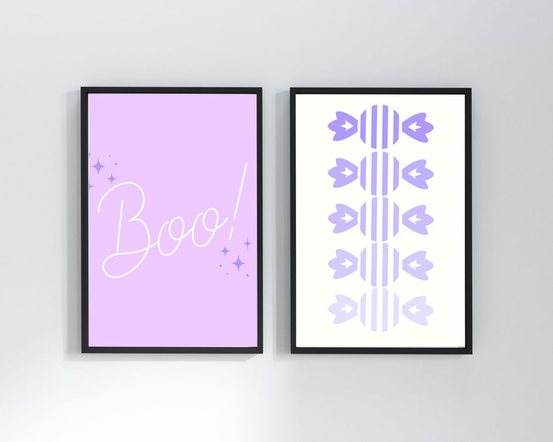 May include: Two framed prints with a Halloween theme. The first print has a light purple background with the word "Boo!" in white cursive. The second print has a white background with a pattern of purple candy canes.