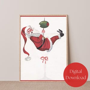 Op de afbeelding: Een digitale download van een printbare illustratie met een kerstman die aan een martini-glas hangt met een olijf. De illustratie is in vintage stijl met de kleuren rood, wit en groen.
