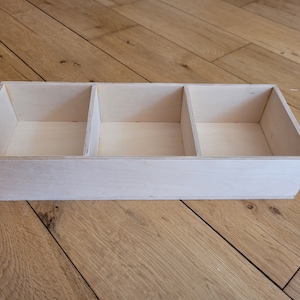 May include: A wooden box with three compartments, each with a smooth, light-coloured finish. The box is empty and ready to be filled.
