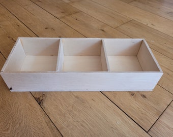 May include: A wooden box with three compartments, each with a smooth, light-colored finish. The box is empty and ready to be filled.