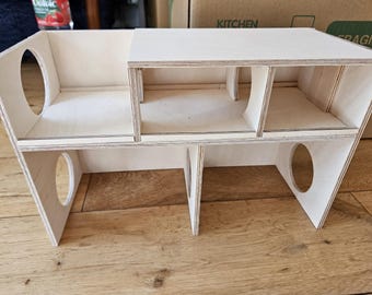 May include: A wooden multi-level playhouse with multiple openings and a white painted finish.