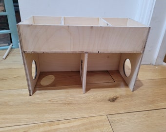 Könnte beinhalten: Eine Holzkiste mit drei Fächern oben und drei Öffnungen unten. Die Kiste ist aus hellem Holz und hat eine natürliche Oberfläche.
