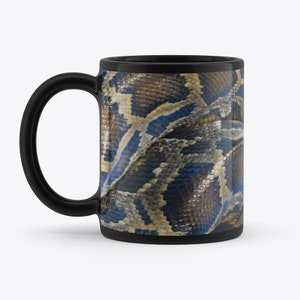 May include: A black ceramic coffee mug with a close-up image of a python snake's skin. The skin is a mix of brown, tan, and blue colors.