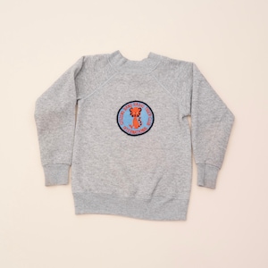 May include: A gray sweatshirt with a blue and orange embroidered patch that says "Citizen Band Radio Tiger Club International".