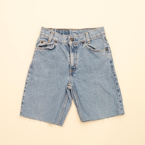 Puede incluir: Pantalones cortos de mezclilla azul claro con dobladillo deshilachado. Los pantalones cortos tienen cinco bolsillos y cierre de botón.