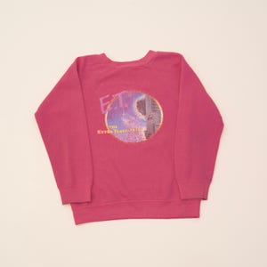 Peut inclure: Sweat-shirt à manches longues rose avec un imprimé graphique d'un personnage du film E.T. l'extra-terrestre.
