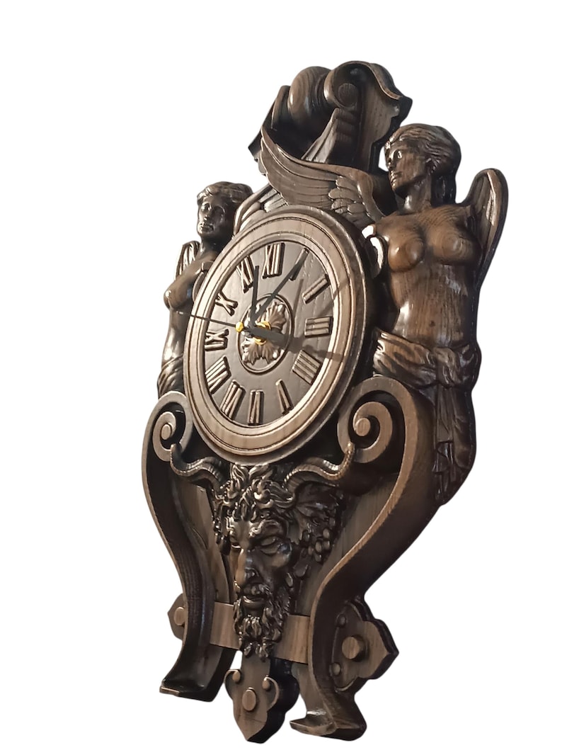 May include: A bronze-colored wall clock with Roman numerals and ornate carvings. The clock features two sculpted figures, wings, and a face with a beard. The clock hands point to approximately 2:10.